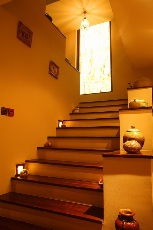 Cầu thang được ốp gỗ, khá rộng và thoáng. Hai bên cầu thang đặt những món đồ bằng sành, sứ.